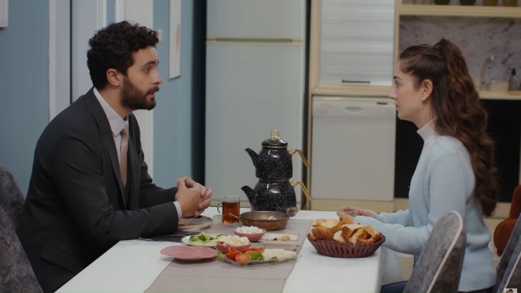 Engin i Sila siedzą naprzeciwko siebie przy śniadaniu.