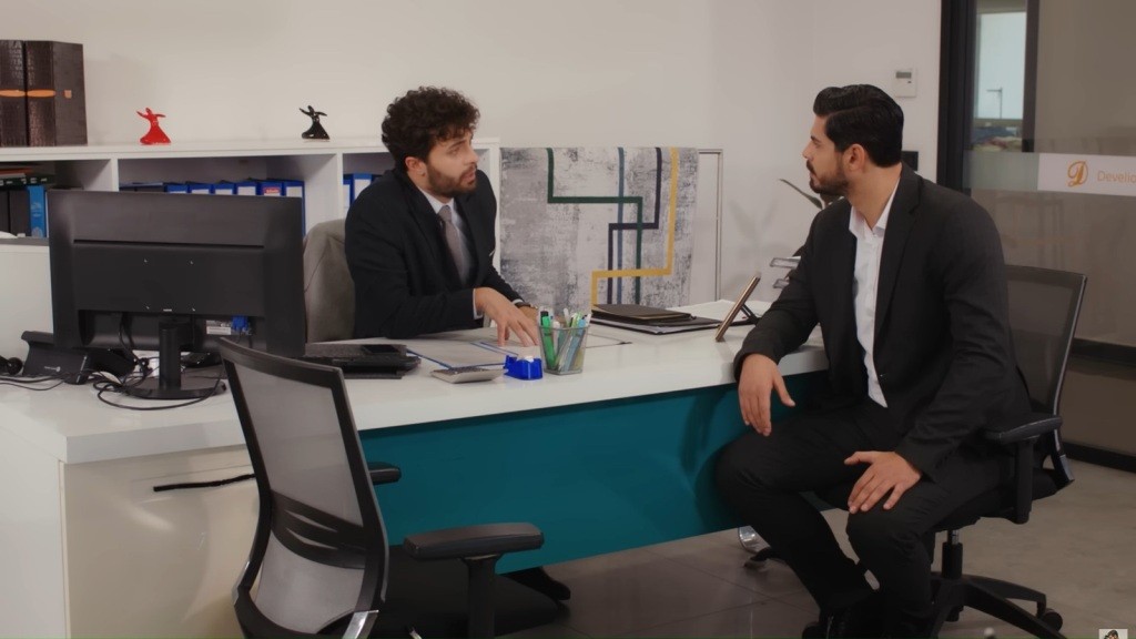 Cihan i Engin siedzą przy biurku w gabinecie.