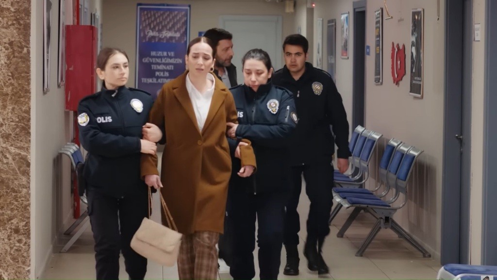 Policjantki prowadzą Beyzę korytarzem. Z tyłu widać Nusreta i policjanta.