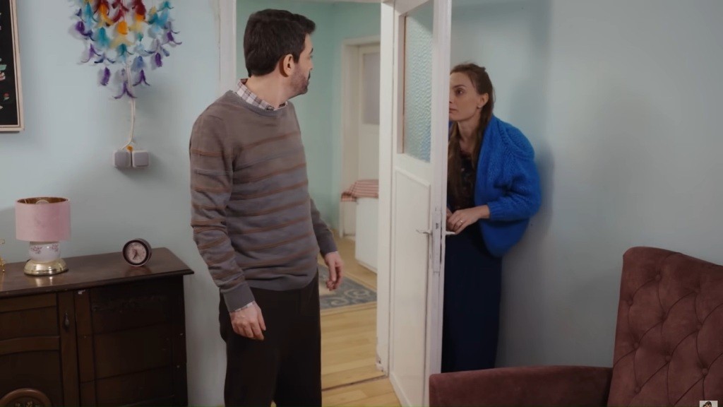 Derya chowa się za drzwiami. Cemil stoi po drugiej stronie i patrzy na nią ze zdziwieniem.