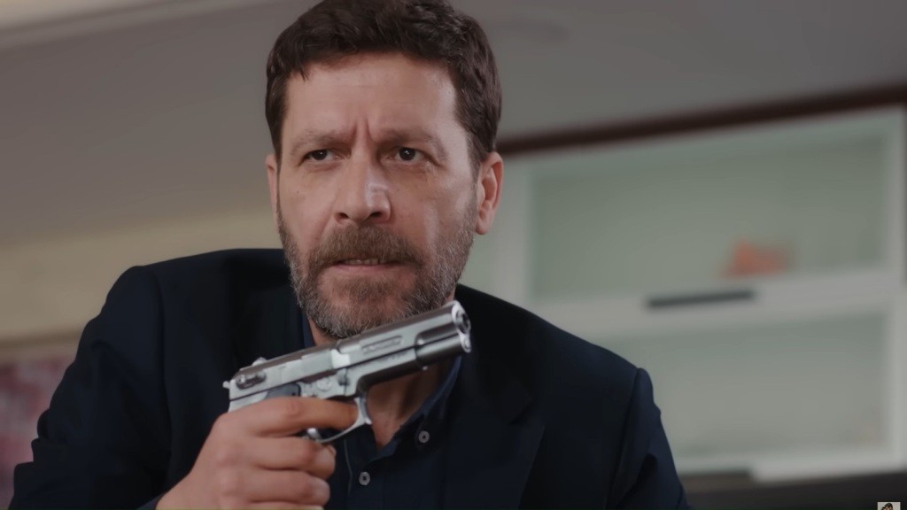 Nusret trzyma pistolet w ręku.