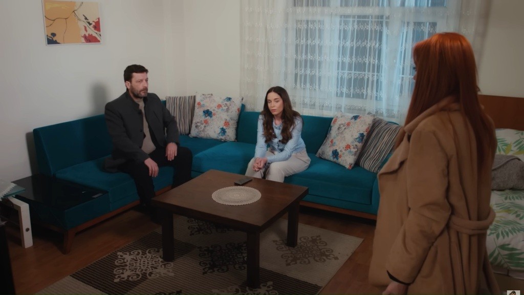 Beyza zatrzymała się w progu salonu, zwrócona twarzą do siedzących na kanapie Nusreta i Beyzy.