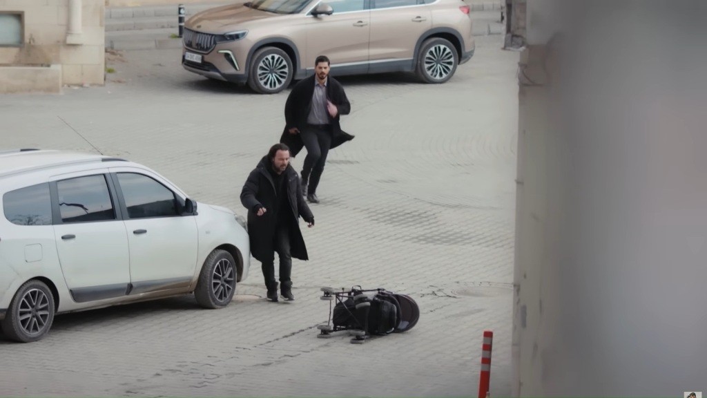 Cihan i kierowca białego vana biegną w kierunku przewróconego wózka dziecięcego.