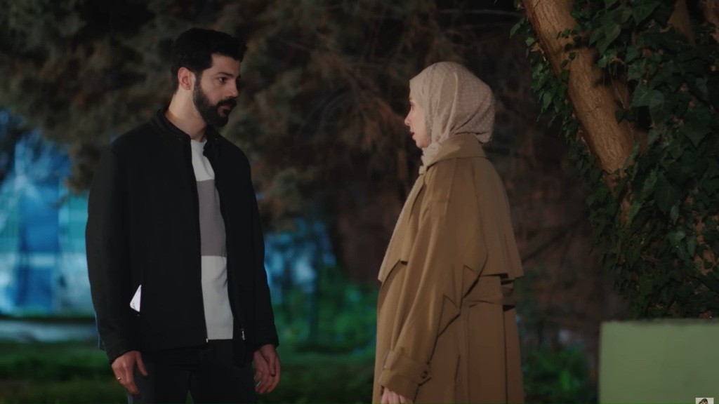 Melih i Sinem rozmawiają nocą na dziedzińcu.