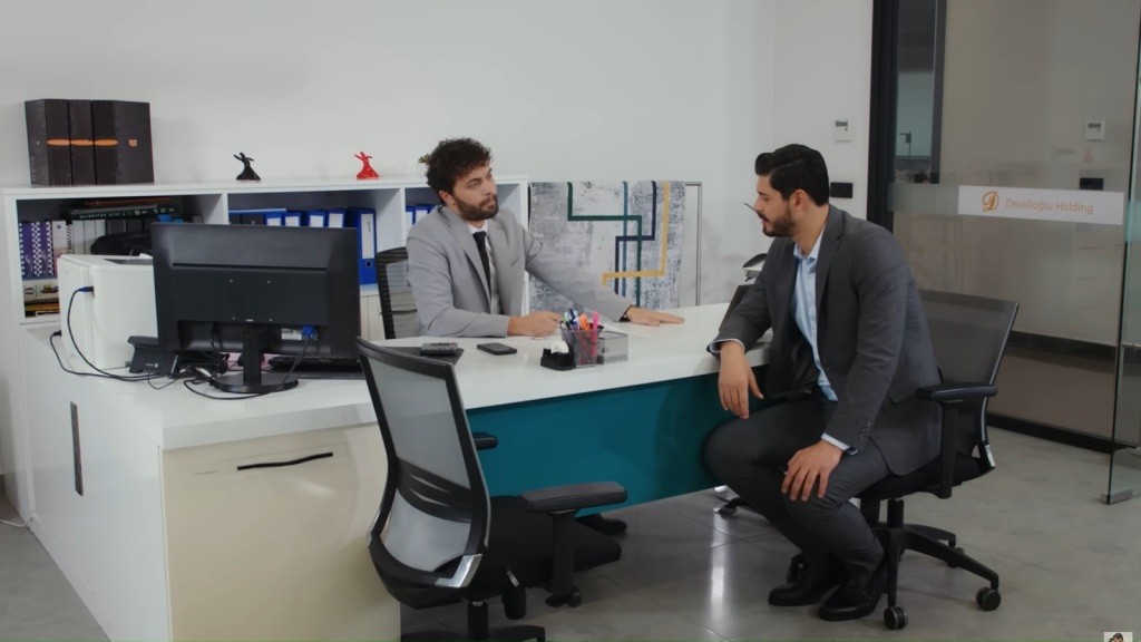 Engin i Cihan rozmawiają w gabinecie.