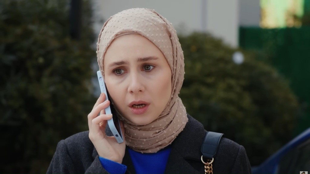 Sinem z przejęciem rozmawia przez telefon.